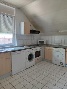 una cocina con lavadora y secadora. en Esma, en Vogošća