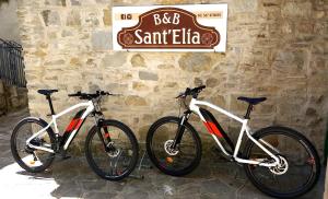 twee fietsen staan geparkeerd naast een stenen muur bij Sant'Elia B&B in Alessandria del Carretto