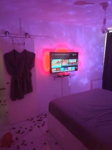 - une chambre avec un lit et une télévision murale dans l'établissement Jennah Spa, à Montereau-faut-Yonne