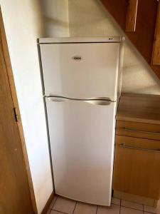 a white refrigerator in the corner of a kitchen at LA O'LISO Gorges de l'Ardèche gîte 4 places avec piscine à 5mn du Pont d Arc in Salavas