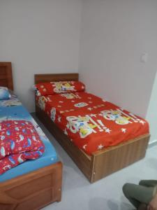 a bedroom with two twin beds with a red blanket at Scandic Resort Hurghada in Hurghada