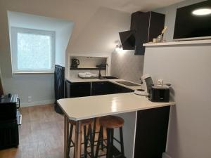 a small kitchen with a counter and stools in it at Colibri Studio in Courtils