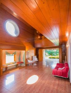 Villa di design con grande parco في تريفيزو: غرفة معيشة مع أريكة حمراء وسقوف خشبية