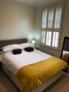 a bedroom with a large bed with a yellow blanket at Stylish & spacious 3 bed Victorian house sleeps up to 7 - near O2, Museums, Excel, Mazehill station 12 mins direct into London Bridge in London