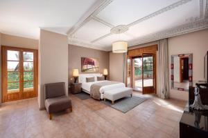 - une chambre avec un lit et une chaise dans l'établissement Domaine Abiad, à Marrakech