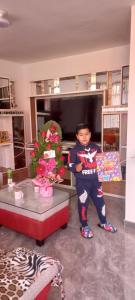 Un jeune garçon debout à côté d'une table dans une pièce dans l'établissement Refugio de la felicidad, à Huancayo