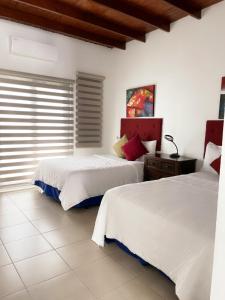 a bedroom with two beds and a window at Casa Campo Bed & Breakfast in San Sebastian