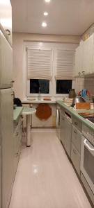 a kitchen with white cabinets and a white floor at Apartment mit Herz in Sondershausen