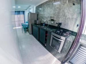 a kitchen with a stove and a sink and a refrigerator at Ubatuba Prime House ap13 in Ubatuba