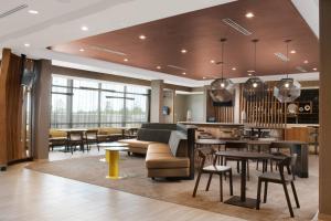 a lobby of a hotel with tables and chairs at SpringHill Suites by Marriott Texas City in Texas City