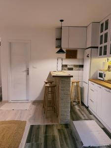 a kitchen with white cabinets and a counter with stools at Sanska 25 in Dušanovac (historical)