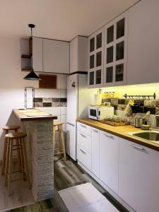 a kitchen with white cabinets and a counter top at Sanska 25 in Dušanovac (historical)
