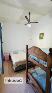 a bedroom with two beds and a ceiling fan at Casa en Paso De La Patria in Paso de la Patria