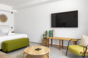 a living room with a bed and a tv on a wall at דירה מדהימה 100 מטר מהים עם חניה פרטית - By Edomlux in Eilat