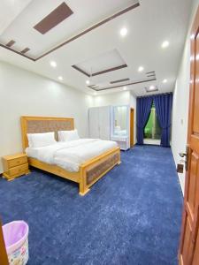 ein Schlafzimmer mit einem Bett und einem blauen Teppich in der Unterkunft River Garden Hotel and Resort in Nārān
