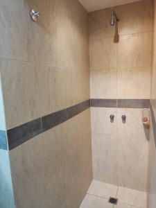 a bathroom with a shower with beige and gray tiles at Velez Dpto in Río Tercero
