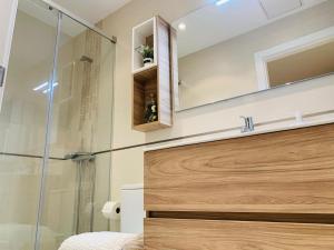 ein Bad mit einer Dusche, einem Waschbecken und einem Spiegel in der Unterkunft Viveiro Centro Histórico in Viveiro