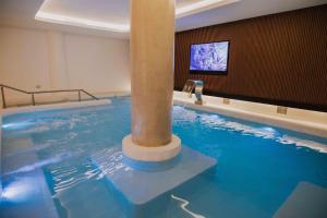 ein großes Schwimmbecken mit einer Säule in einem Raum in der Unterkunft Hotel Dos Reyes in Mar del Plata