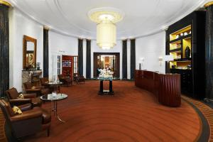 una hall con sedie, tavoli e lampadario a braccio di Hotel Bristol, a Luxury Collection Hotel, Vienna a Vienna