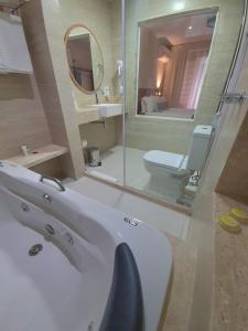 uma casa de banho com um lavatório, um WC e um espelho. em Pousada Rubi em Abraão