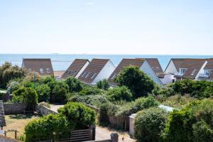 a row of houses with the ocean in the background at Fantastic sea views. One Bedroom flat near the sea in Selsey
