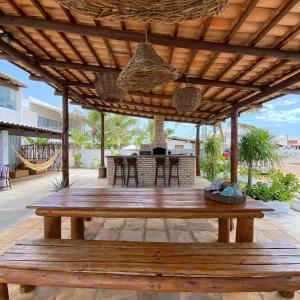 pérgola de madera con mesa de madera en el patio en Villa Jundu en São Miguel do Gostoso