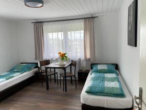 Habitación con 2 camas y mesa con mesa. en FERIENWOHNUNG AM BERG, en Marktgraitz