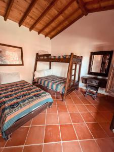 a bedroom with a bunk bed and a chair at Las Orquídeas EcoHostel in Guarne