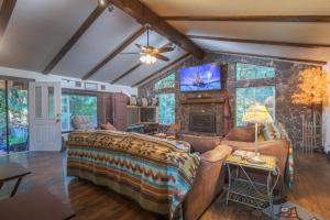 1 dormitorio con 1 cama grande y pared de piedra en Cozy Bird house w Big screen!, en Mount Hood Village