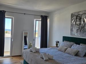 ein Schlafzimmer mit einem Bett und einem großen Fenster in der Unterkunft Apartman Nella with sea wiew in Zadar