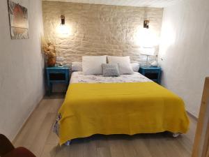 a bedroom with a yellow bed with two blue tables at Gîte en Provence ''Rose'' in Modène +41 photos