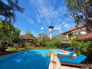 een zwembad met blauwe stoelen en een huis bij Balinda Rooms & Villa in Lovina