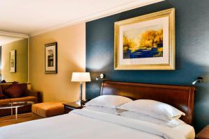 1 dormitorio con 1 cama y una pintura en la pared en Sheraton Skyline Hotel London Heathrow en Hillingdon