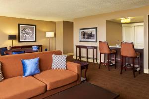 a living room with a couch and a bar at Sheraton North Houston at George Bush Intercontinental in Houston