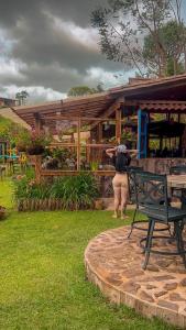 a woman standing in front of a wooden building at Las Orquídeas EcoHostel in Guarne
