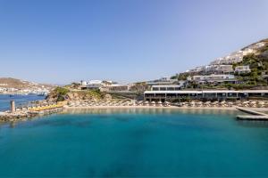 une grande étendue d'eau avec des chaises et des bâtiments dans l'établissement Santa Marina, A Luxury Collection Resort, Mykonos, à Ornos