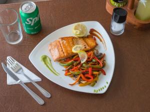 a plate of food with fish and vegetables on a table at Hotel Econohotel in Los Ángeles