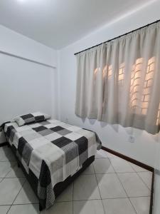 Schlafzimmer mit einem schwarzen und weißen Bett und einem Fenster in der Unterkunft Apartamento com mobília nova 101! in Francisco Beltrão