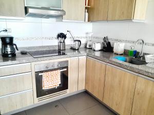 a kitchen with a stove with an oven in it at Stylish New Apartment with stunning Ocean View near Miraflores in Lima +21 photos
