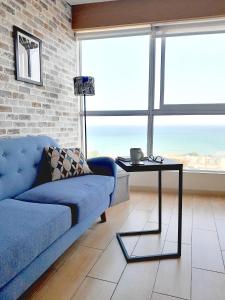 sala de estar con sofá azul y mesa en Stylish New Apartment with stunning Ocean View near Miraflores, en Lima