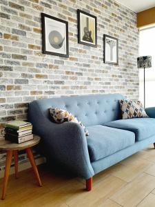 利馬的住宿－Stylish New Apartment with stunning Ocean View near Miraflores，客厅里设有蓝色的沙发,设有砖墙