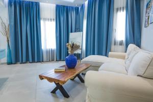 uma sala de estar com cortinas azuis e um vaso sobre uma mesa em Theoxenia Kasos Luxury Apartments em Panayía