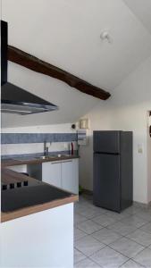 uma cozinha com um frigorífico de aço inoxidável e um lavatório em Charme & Tranquilité au centre de Malesherbes-2P 