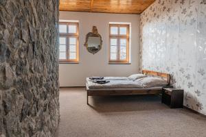 um quarto com uma cama e uma parede de pedra em Penzion hrad Doubravka em Teplice