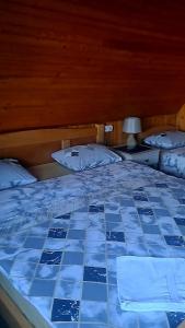 Una cama con un edredón azul y blanco. en Vila Durmitor Nest Krstajic en Žabljak