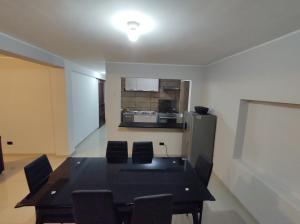 ein Esszimmer mit einem Tisch und Stühlen sowie einem Kühlschrank in der Unterkunft Departamento amplio in Huancayo
