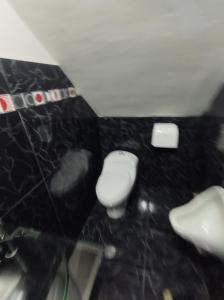 ein Badezimmer mit zwei WCs und einer schwarzen Wand in der Unterkunft Departamento amplio in Huancayo