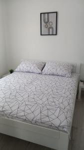 a white bed in a white room with a bed frame at Apartmani HERMES Jadrija in Šibenik