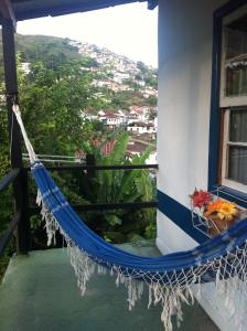 un balcón con hamaca y vistas a la ciudad en Pousada Ciclo do Ouro, en Ouro Preto