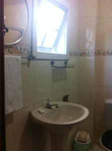 La salle de bains est pourvue d'un lavabo et d'une fenêtre. dans l'établissement Pousada Ciclo do Ouro, à Ouro Preto